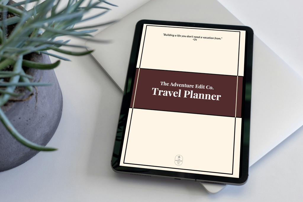 Tablet displaying a travel planner app on a white surface with a plant.